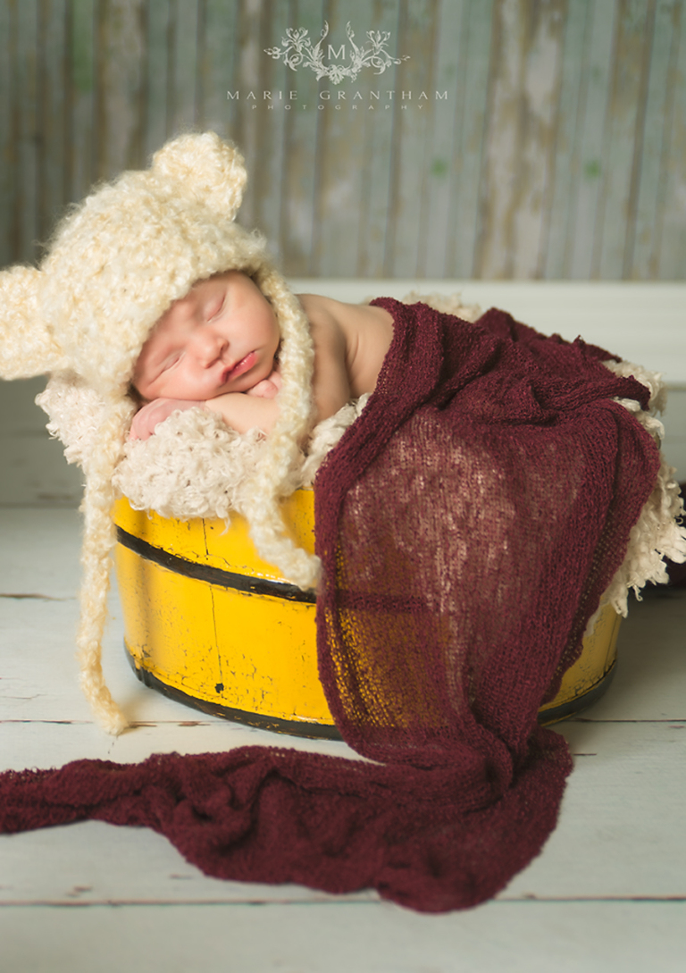 newborn photographer marie grantham photography captures newborn baby in a yellow bucket