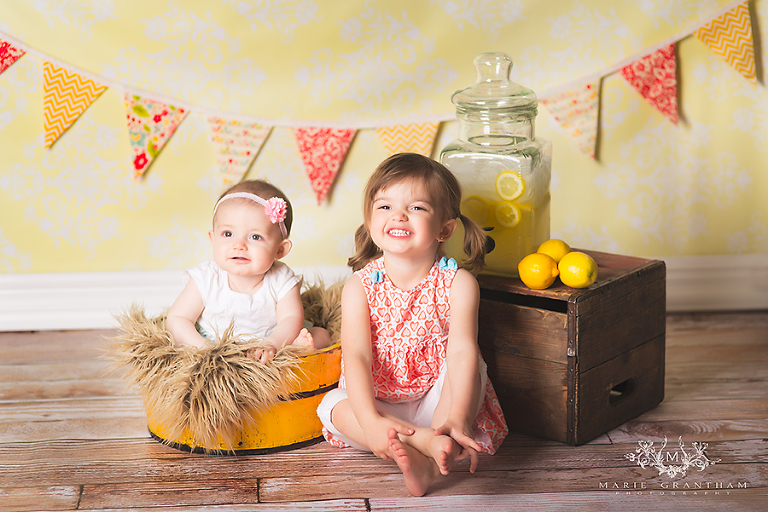 two sisters taking summer themed lemonade stand photo session in henderson, nv