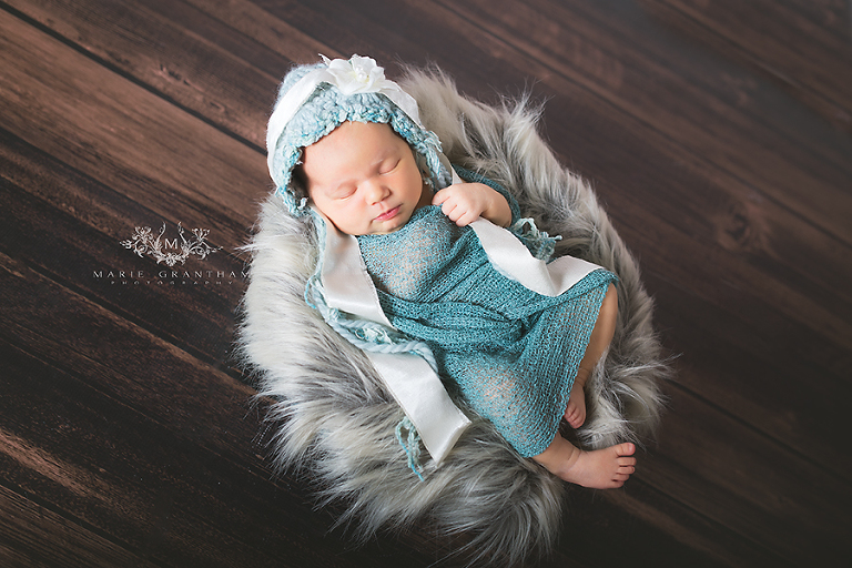 newborn photographer henderson marie grantham photography captures photo of tiny baby girl asleep with aqua wrap over her
